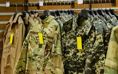 挂在带有销售和价格标签的货架上的战术军服的照片.