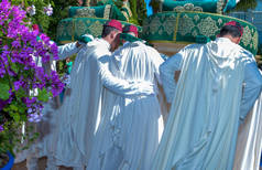 Moroccan men carrying grooms on Amaria. Wedding Traditions in Morocco