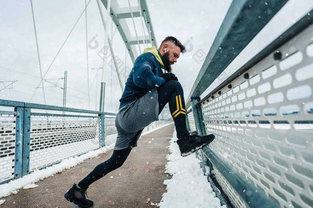 一个英俊的中年男人，留着胡子在外面跑来跑去，在寒冷的<strong>大雪</strong>中锻炼。运动和健身动机<strong>主题</strong>.