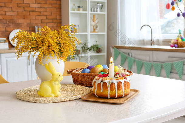 厨房饭桌上的复活节蛋糕、兔子和美丽的油菜花
