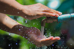 Water concept in everyday life. Hands supporting the water flowing from the faucet. water splashing 