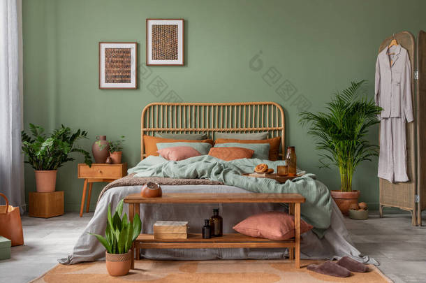 风格新颖的居室室内设计，配有模拟海报框架、竹床、床铺、床头柜、植物、折叠式屏风和创意家居配件。桉树墙。模板。复制空间.