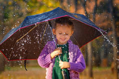 秋天公园里，在蘑菇雨中带雨伞的女孩.