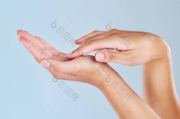 用<strong>女性</strong>的手捂住她的手掌。一个有着柔软、完美、保湿的皮肤的女人，被蓝色的背景隔离。秀丽的手指显示出修指甲和卫生。护肤和<strong>美容</strong>疗法.