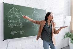 课堂教学中，教师在黑板上指点数学公式