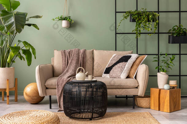 客厅内部的时尚构图与设计米色沙发，黑色咖啡桌，植物和典雅的个人配饰。棕色枕头和格子花。舒适的公寓家居装饰