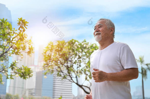 快乐而微笑的亚裔老人在夏天退休后在户外公园里做运动、慢跑或散步，以保持<strong>健康</strong>。<strong>老年人</strong>户外保健生活方式概念.