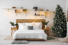 有圣诞树、架子和灯火通明的卧室内部