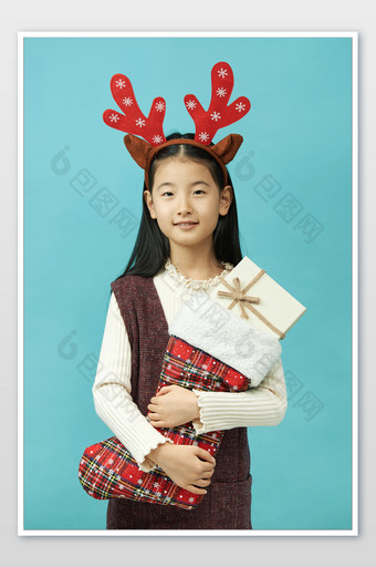 圣诞节抱着圣诞袜和礼物的小女孩图片