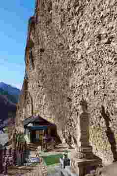 岩石山脚寺庙建筑佛像摄影图