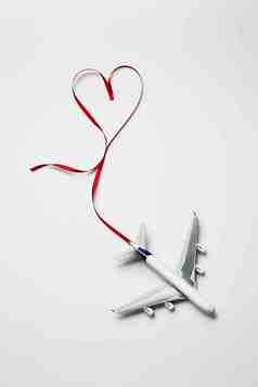 浪漫的丝带爱心飞机模型摄影图