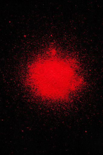 大红色粉末喷溅在黑色背景特写摄影图