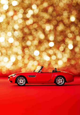 红色敞篷汽车模型金色背景静物摄影图
