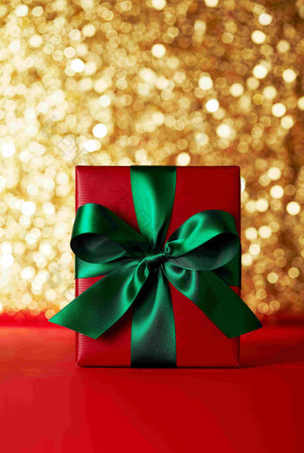 黄金背景绿色丝带圣诞礼物盒