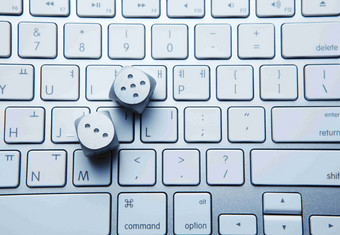 笔记本键盘上的白色骰子背景摄影图