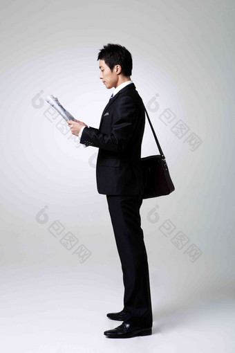 手持报纸阅读的商务男士正装摄影图