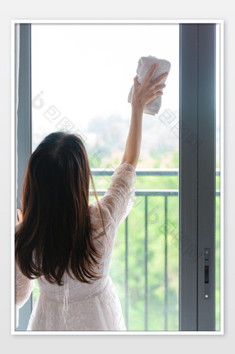 擦窗户的女性背影图片