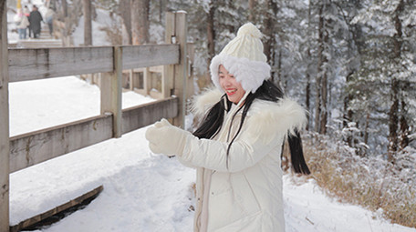 东方人像女孩雪地打雪仗开心玩耍实拍