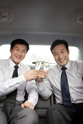 两个<strong>商务男士</strong>车后座喝香槟