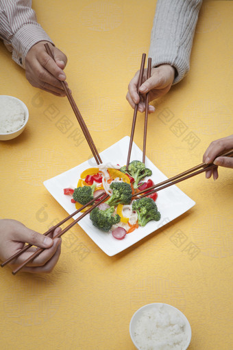 用筷子夹菜的人们摄影图