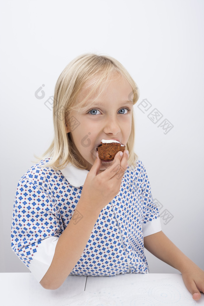 简约风格吃蛋糕的小孩摄影图