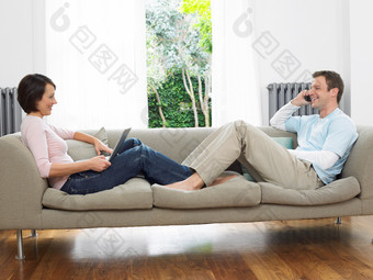 简约沙发上的年轻夫妻摄影图