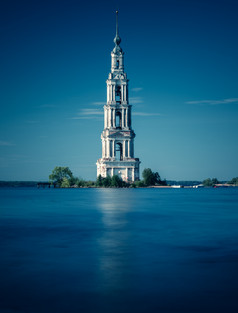蓝色调水中的高塔摄影图