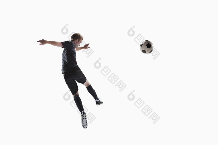 穿黑色运动服的运动员跳跃踢球