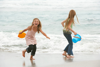 拿沙滩桶海边玩耍的女孩