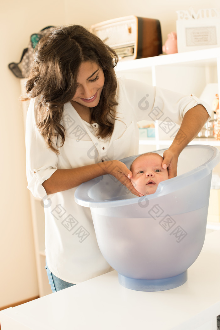 深色调给婴儿洗澡摄影图