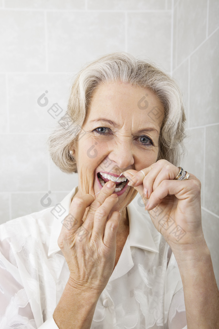 灰色调用牙线的老人摄影图