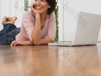 趴在地上玩电脑的女人