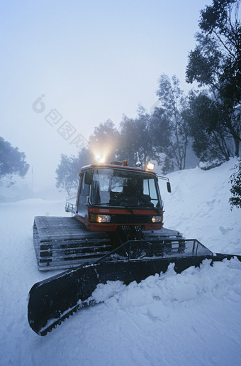 蓝色调推雪的机械车摄影图