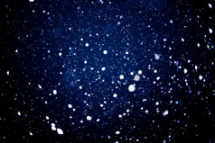 夜晚空中的飘雪摄影图