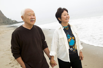 沙滩牵手散步的老年夫妻