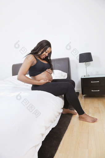 坐在床上的<strong>孕妇</strong>摄影图