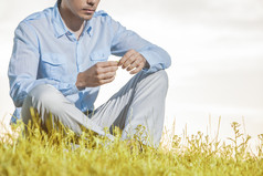 清新坐草坪上的男人摄影图