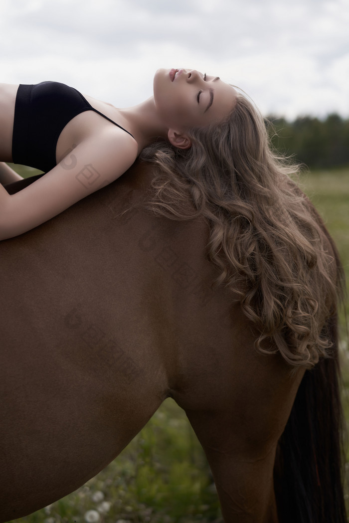 深色调在马背上的女孩摄影图