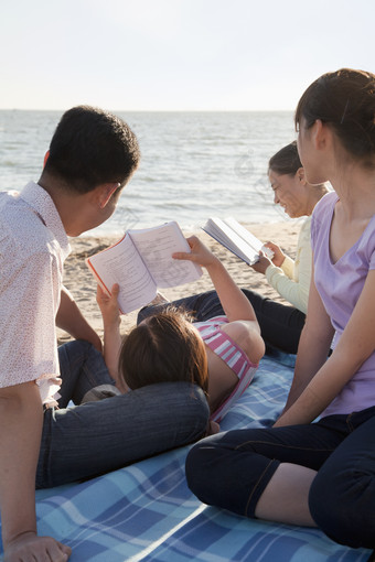 海边看书的一家人
