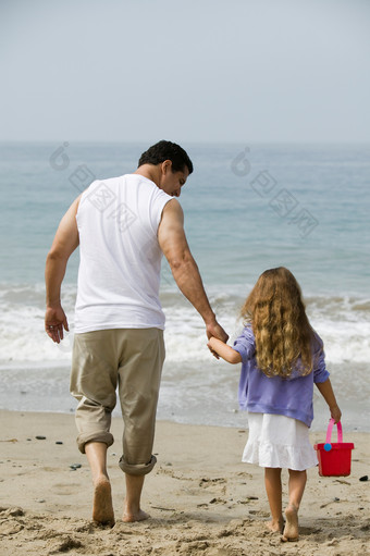 父亲领着<strong>孩子</strong>在海边玩