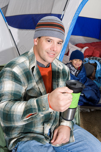 帐篷喝水的男人摄影图