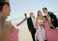蓝色调在海边拍照的新婚夫妻摄影图