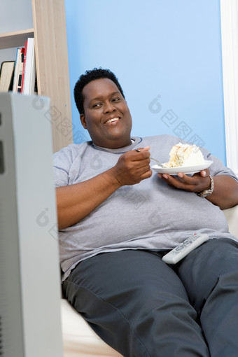 深色调吃东西的胖子摄影图