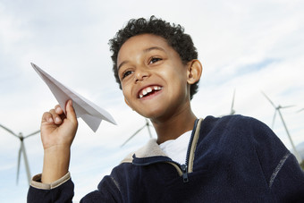 暗色调玩纸飞机的孩子摄影图