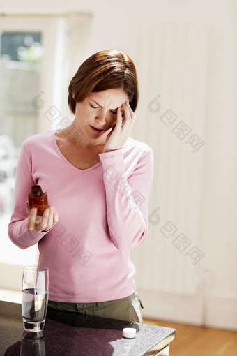 头疼吃药的女人摄影图