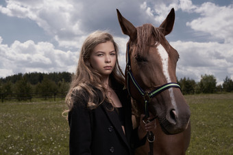 暗色调草地中的女孩和马摄影图