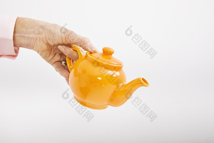 灰色调手中的茶壶摄影图