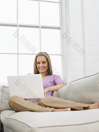 沙发玩电脑的中年女人