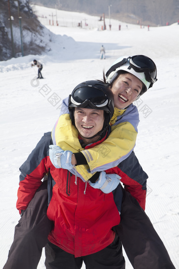滑雪场男人背着女人开心玩耍