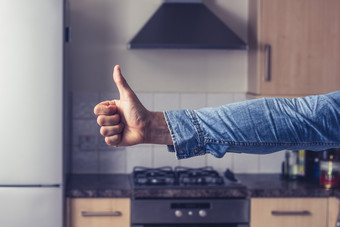 简约厨房竖大拇指的人摄影图